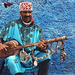 Gnawa musicians playing traditional instruments, guembri, and tbel
