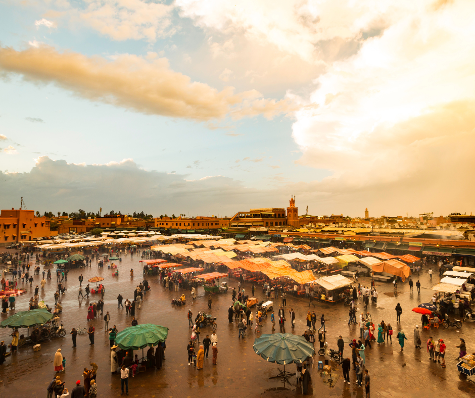 Vibrant henna festival in Marrakech's Jemaa el-Fnaa square, with stalls offering henna tattoos and traditional clothing