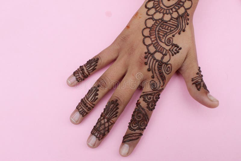 A skilled henna artist applying intricate designs on a bride's hands