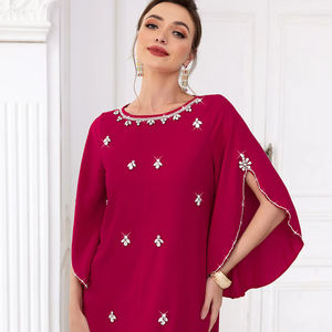 A woman wearing a traditional caftan with intricate embroidery and patterns