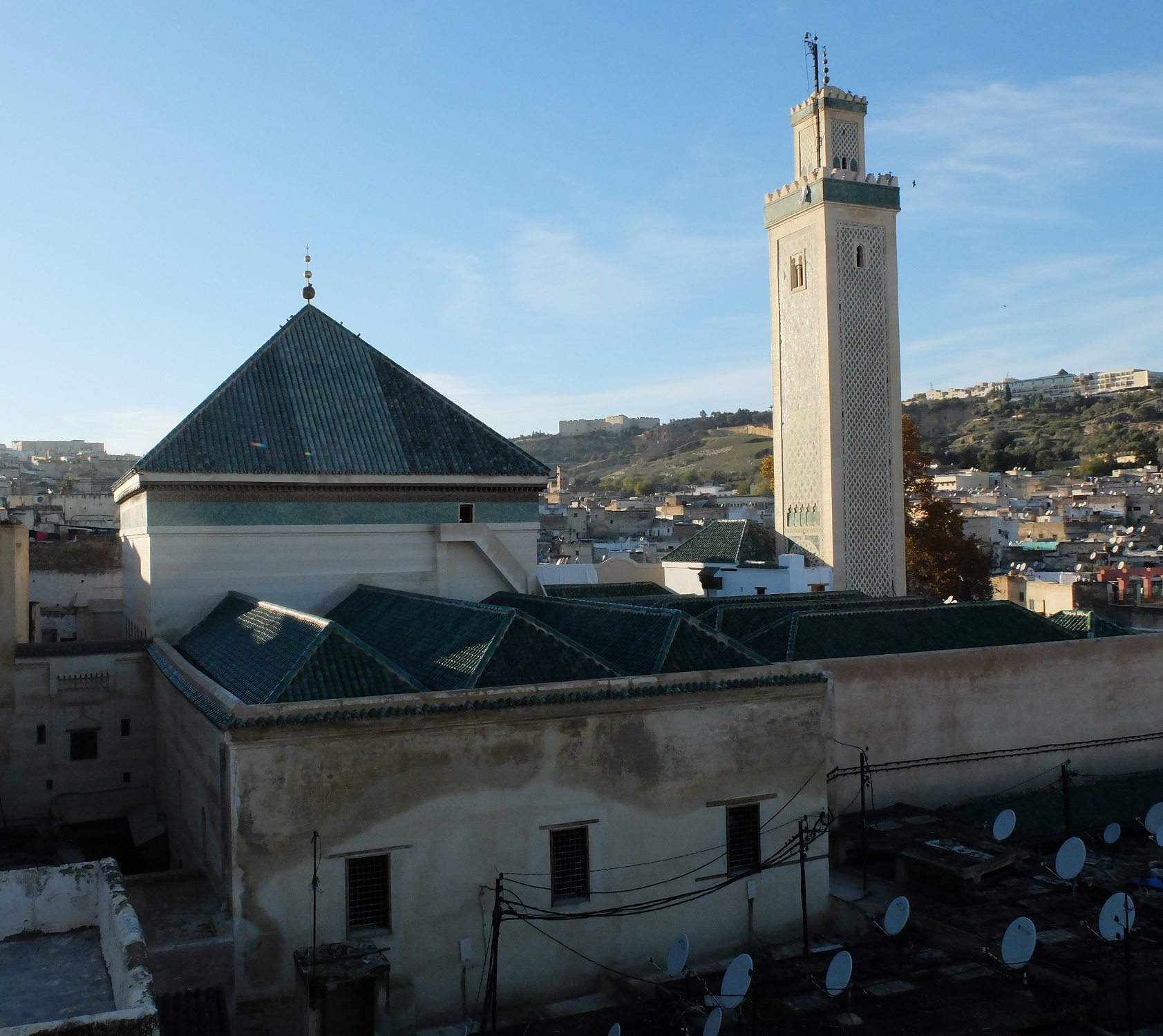 Skilled artisans restoring the intricate tile work and wooden carvings of the Zawiya of Moulay Idriss Zerhoun