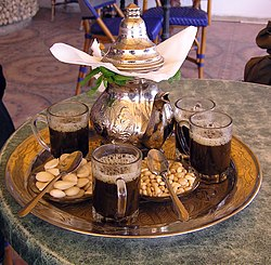 Fresh mint leaves and green tea leaves spread on a traditional Moroccan tea tray