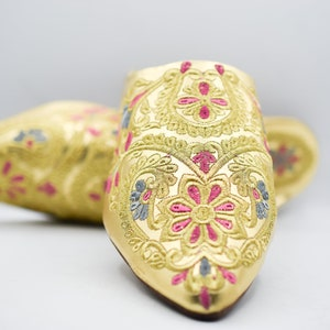 A pair of traditional Babouches with intricate embroidery, showcasing the vibrant colors and craftsmanship